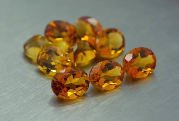 Group of ocher colored gemstones on metal surface